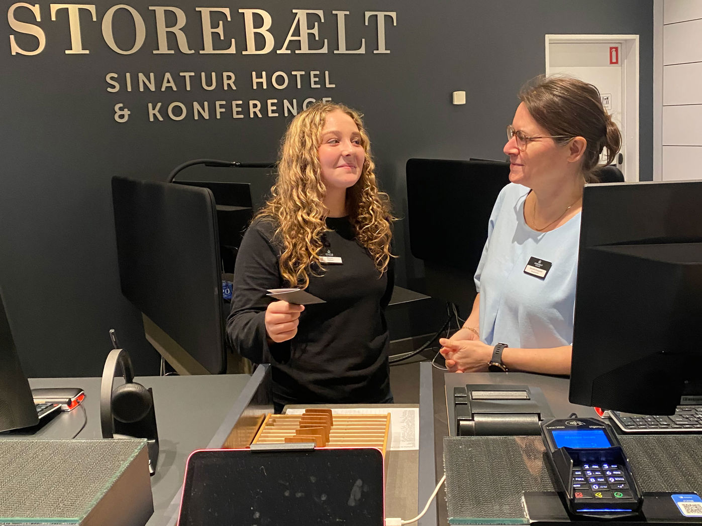 Juniormesterlæreelev lærer at stå i receptionen