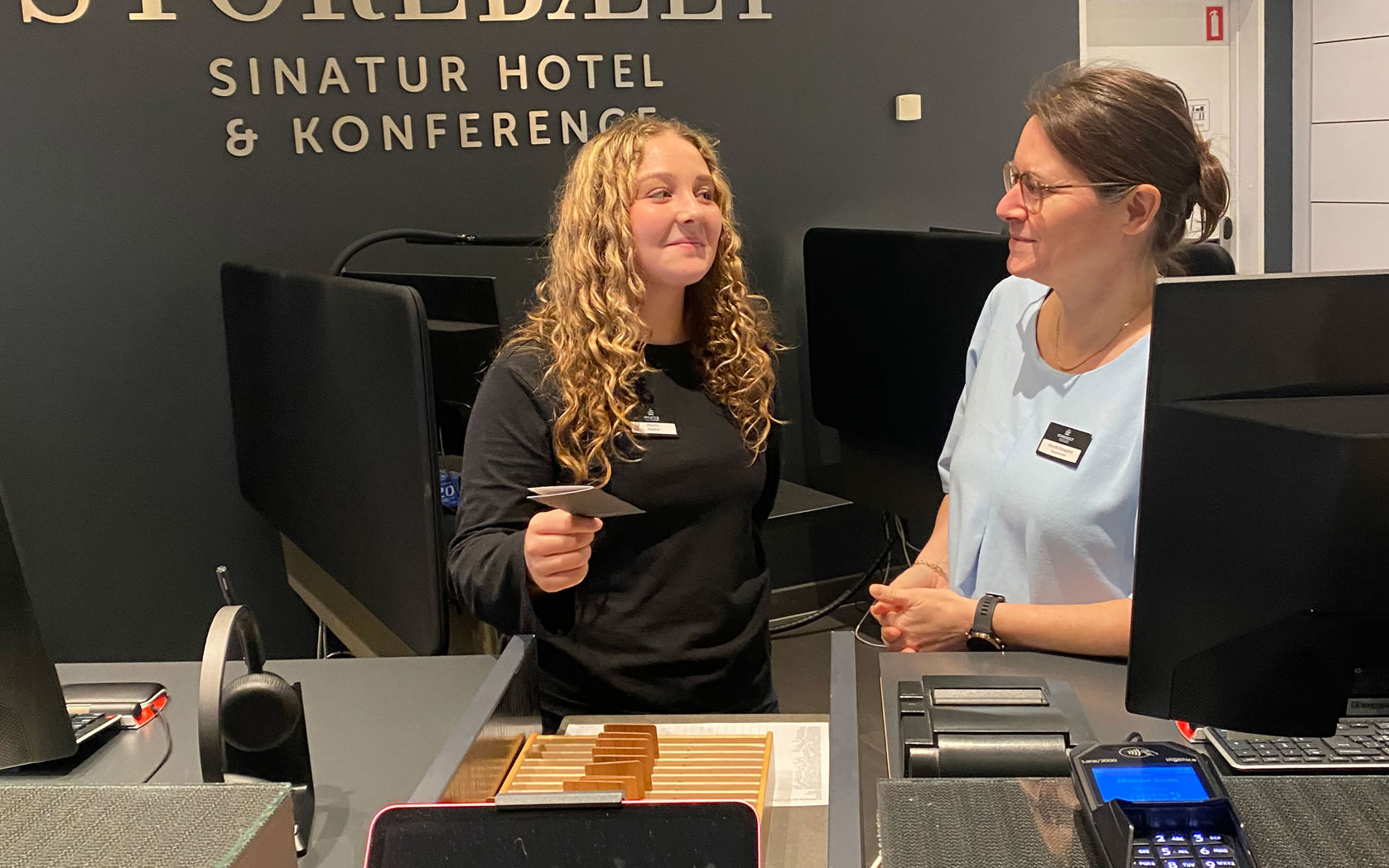 Juniormesterlæreelev lærer at stå i receptionen