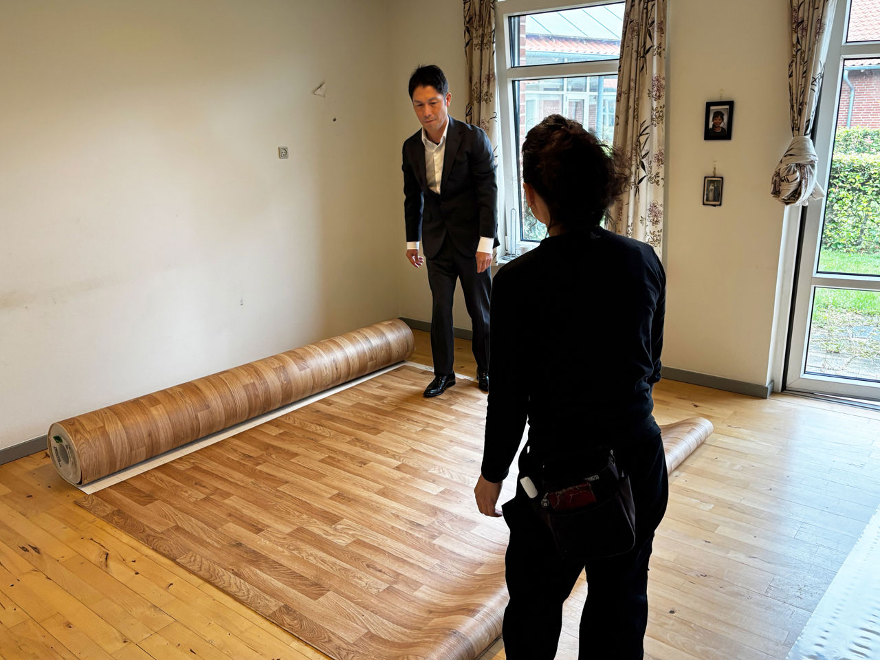 To japanere der lægger fladgulv ud i en lejlighed