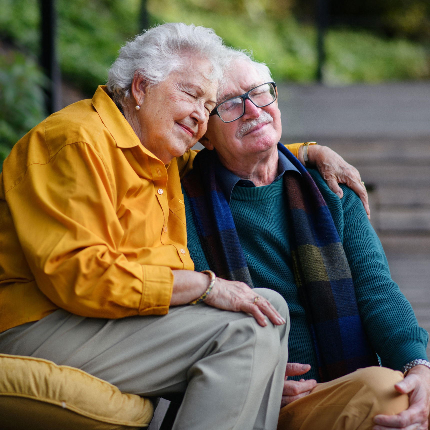 To ældre mennesker der krammer med lukkede øjne