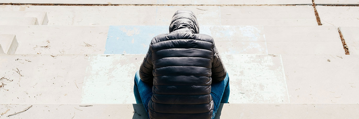 Ryggen af en person med hætten over hovedet